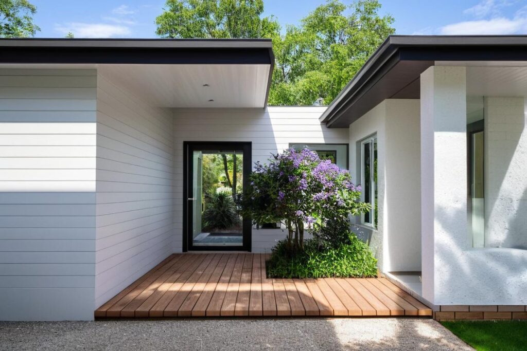 Heritage home extension in Ainslie, Canberra featuring white weatherboard cladding and seamless architectural connection.