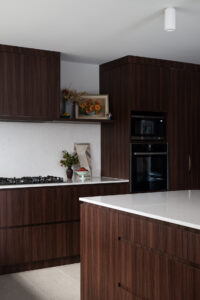 Contemporary home interior in Chisholm, Canberra featuring dark timber kitchens, modern living spaces, and bathrooms.