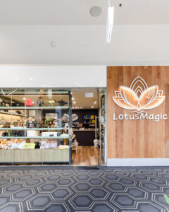 Minimalist retail shop interior in Westfield Belconnen featuring timber display shelves and sage green walls.
